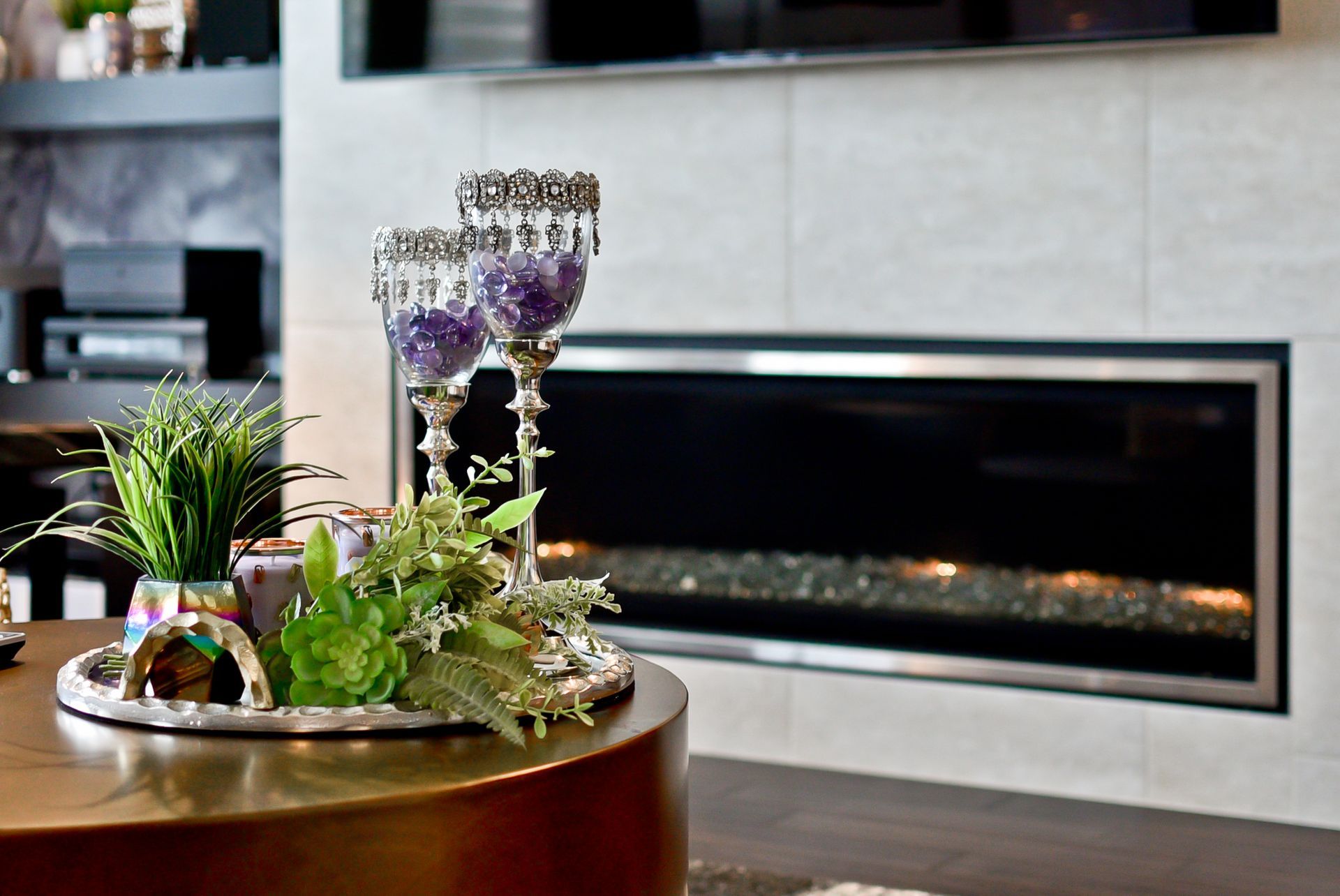 A living room with a fireplace and a table with flowers on it.