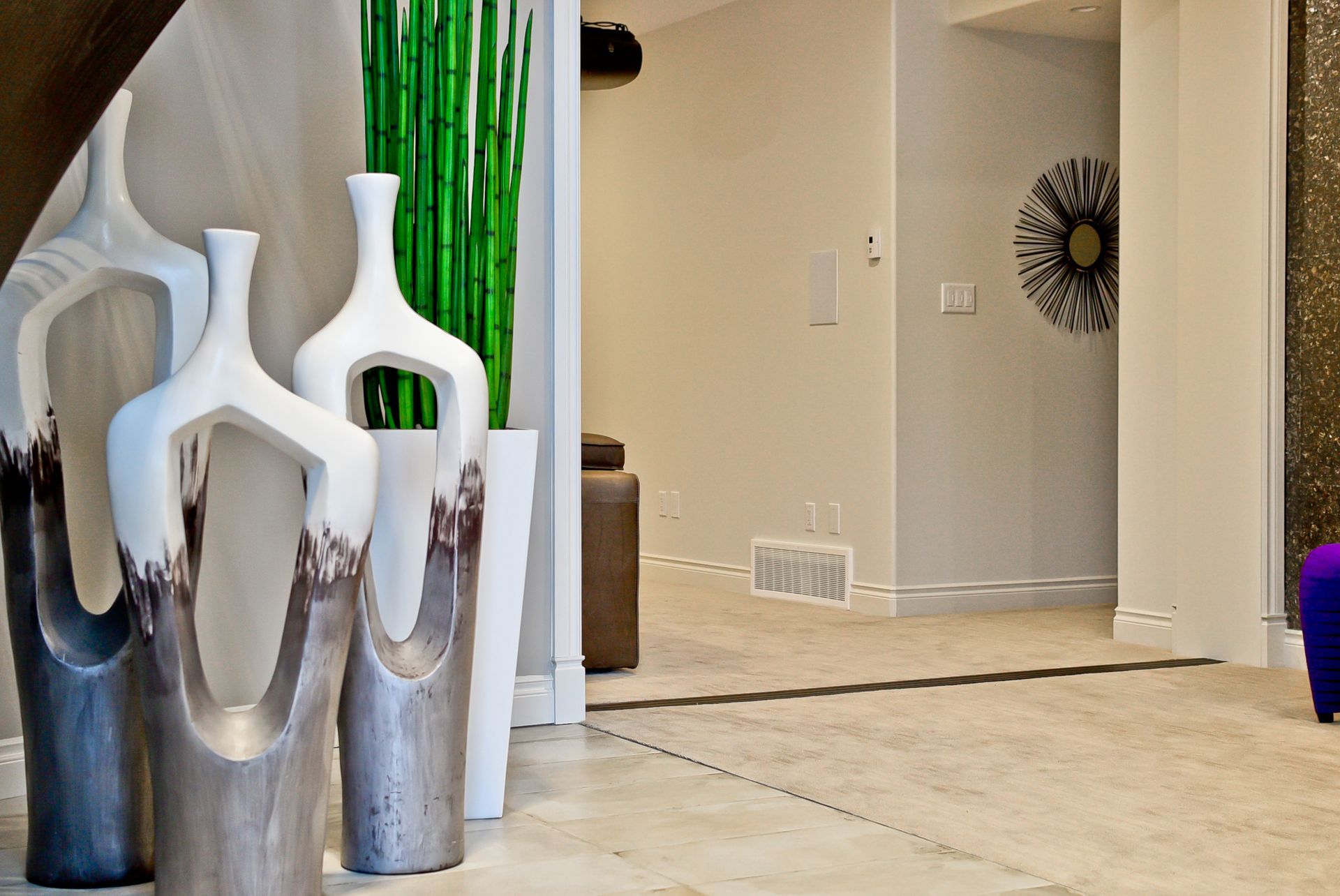 A group of vases are sitting on a tiled floor in a hallway
