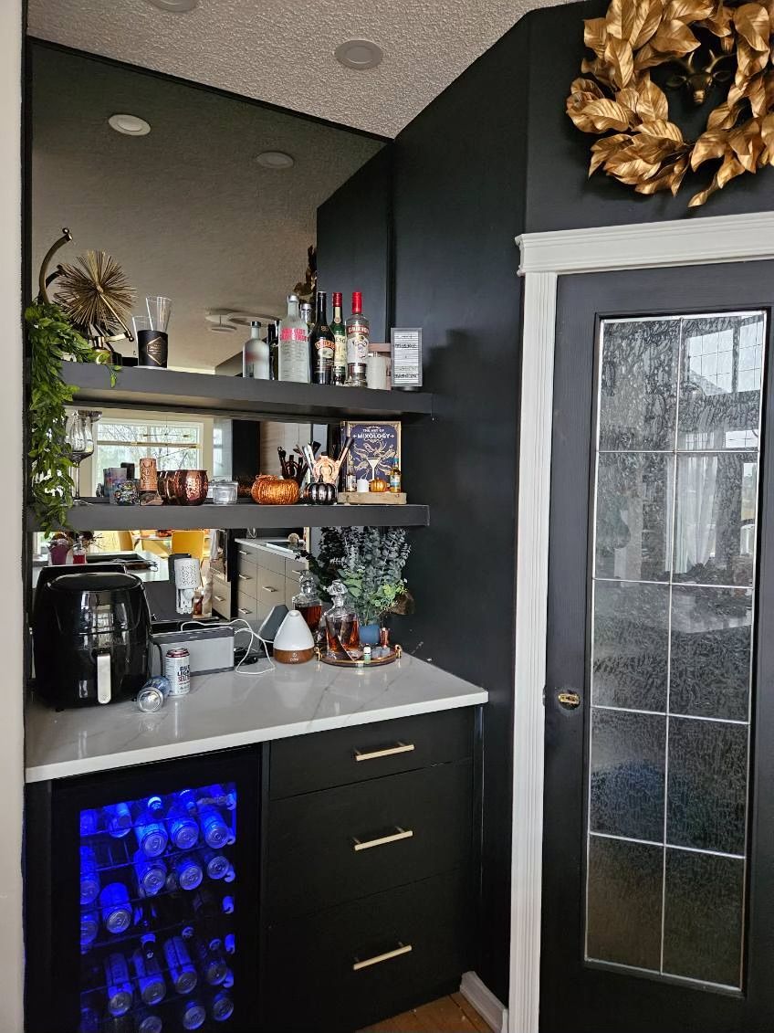 A kitchen with a bar and a refrigerator.