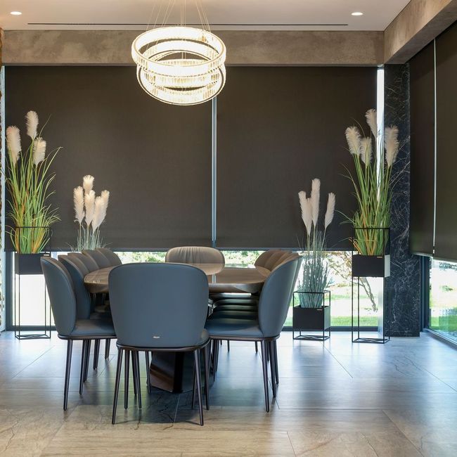 A dining room with a table and chairs and a chandelier