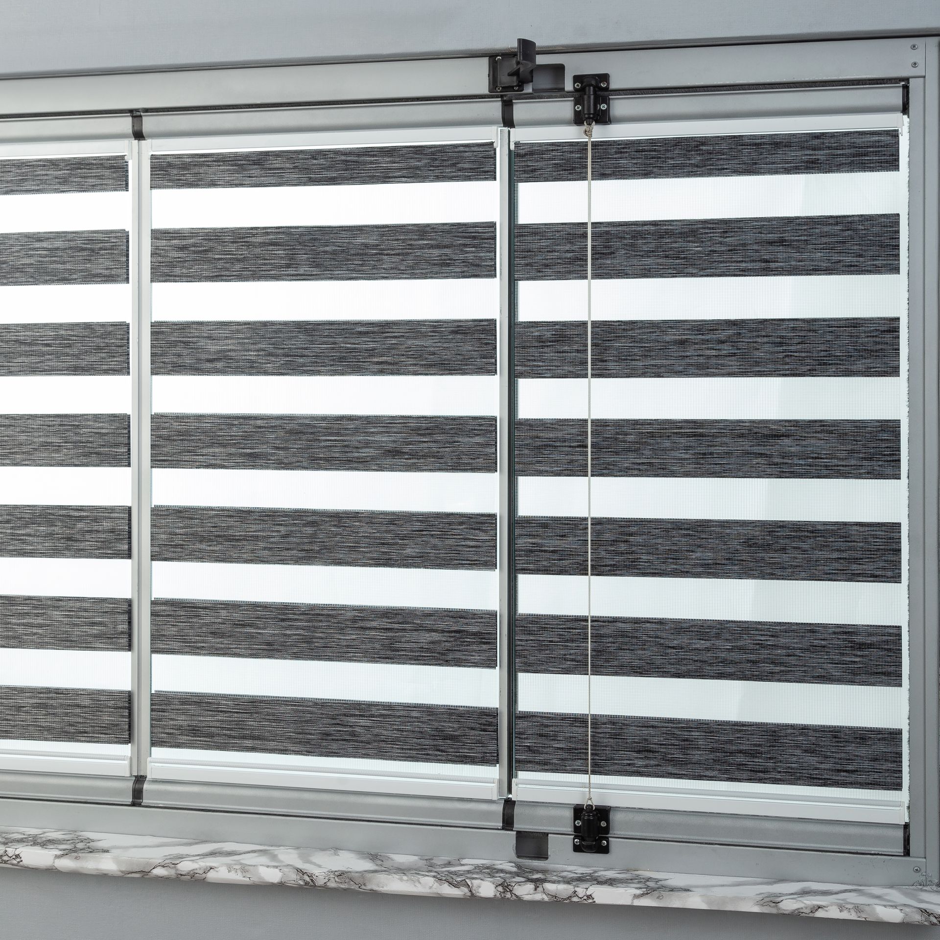 A window with a black and white striped blind on it.