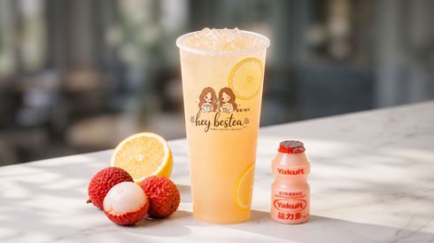 Lemon iced drink with strawberries and a small milk bottle on a sunlit outdoor table