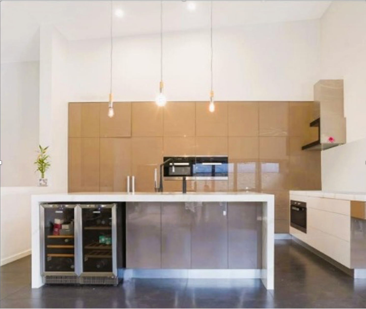 Modern kitchen with a brown glossy cabinets, island with wine cooler, and pendant lights. — Ausplumb NT in Winnellie, NT
