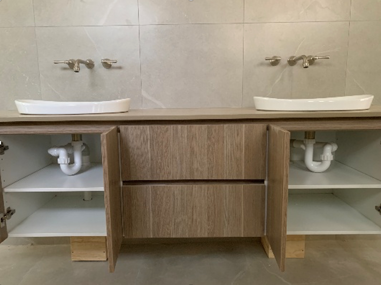 Bathroom vanity with two sinks, wooden cabinets, and wall-mounted faucets. — Ausplumb NT in Winnellie, NT