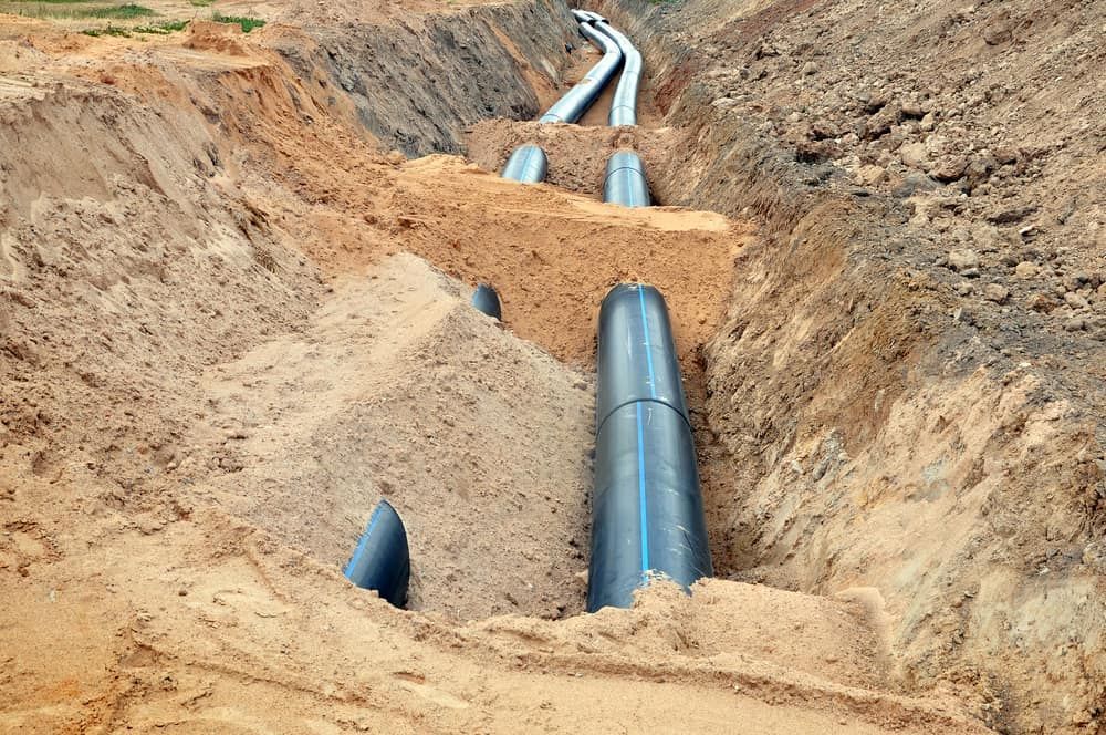 A Water Pipe is Being Installed in a Trench in the Dirt — Ausplumb NT in Winnellie, NT