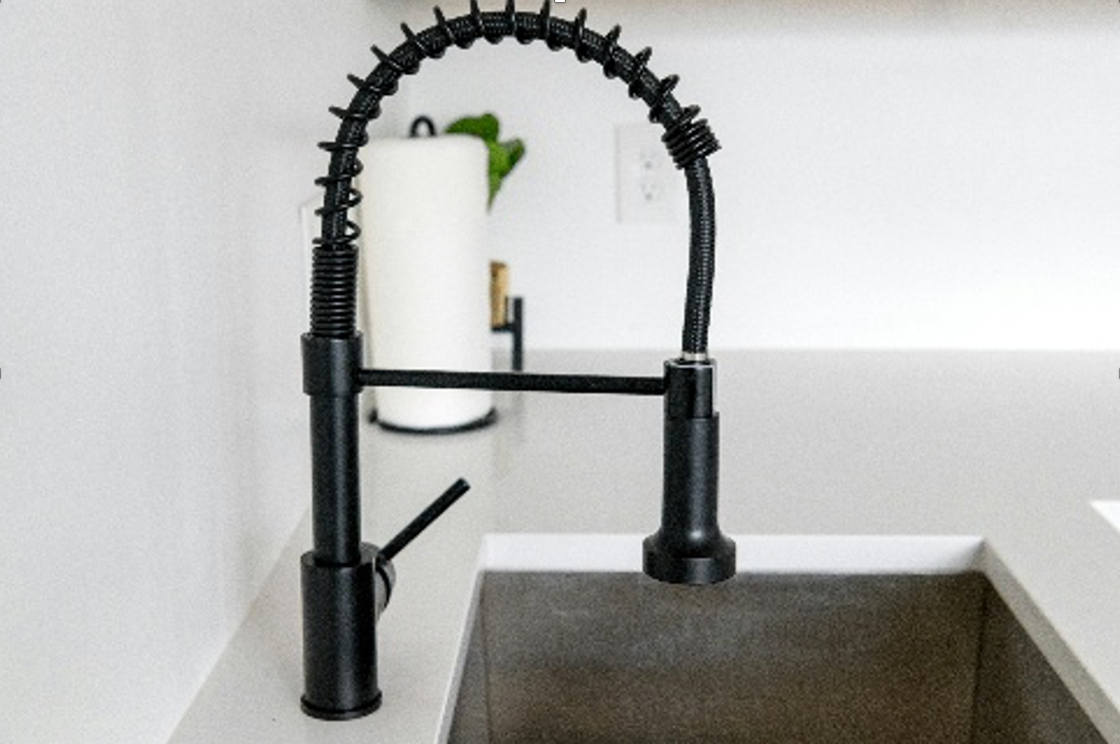 Black kitchen faucet over a grey sink, with a paper towel holder in the background. — Ausplumb NT in Winnellie, NT