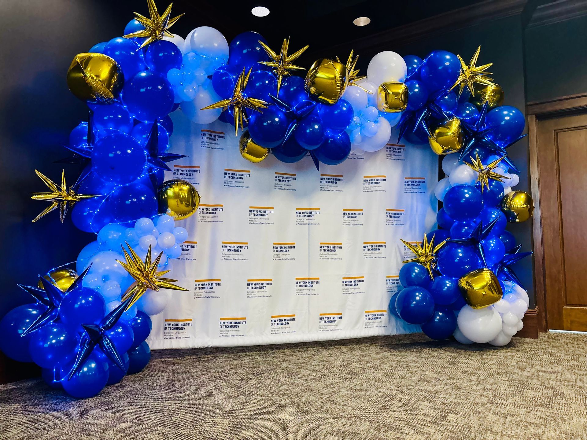 blue, gold, and white balloon arch photo backdrop