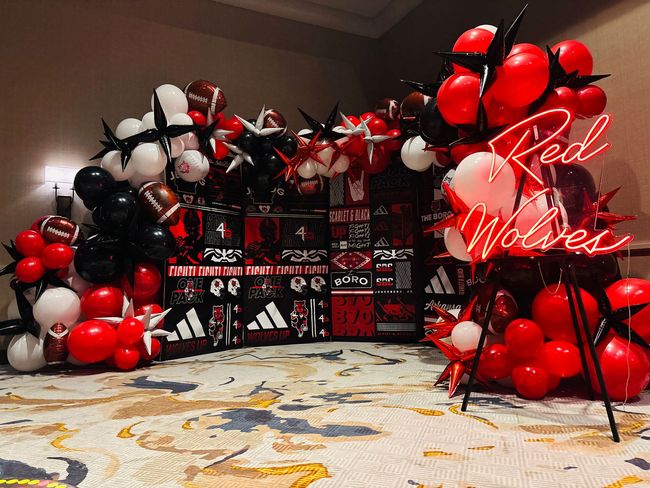 large red and black balloon display for arkansas state athletic event