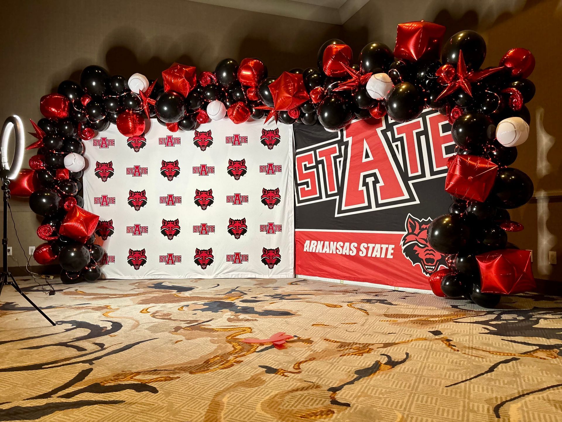 red and black balloon arch for arkansas state event