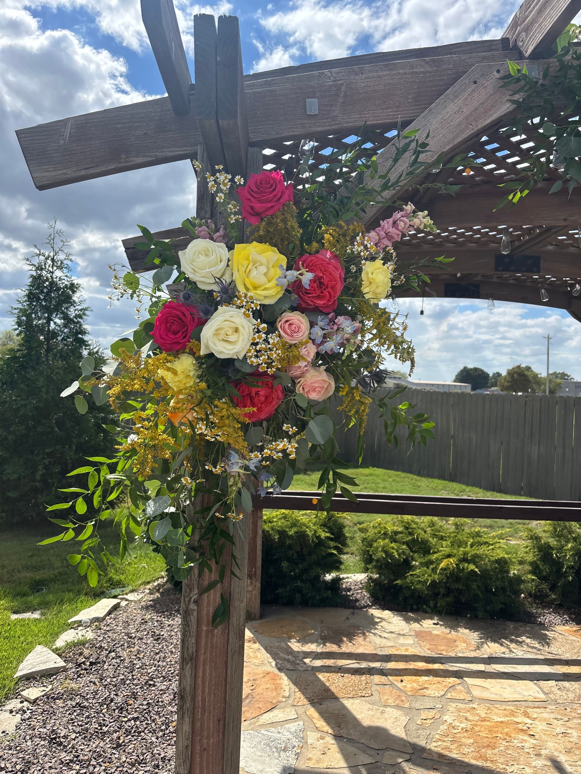 red and yellow rose arrangement attached to pergola