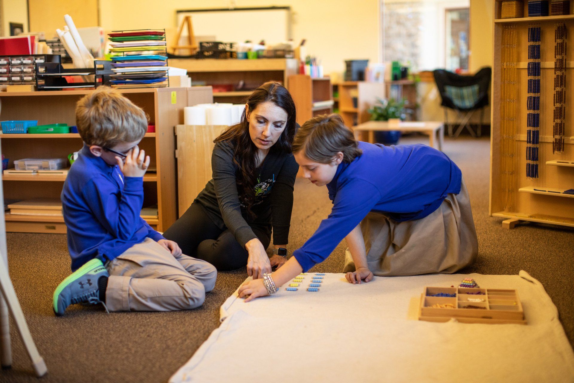Children and guide in a Montessori classroom