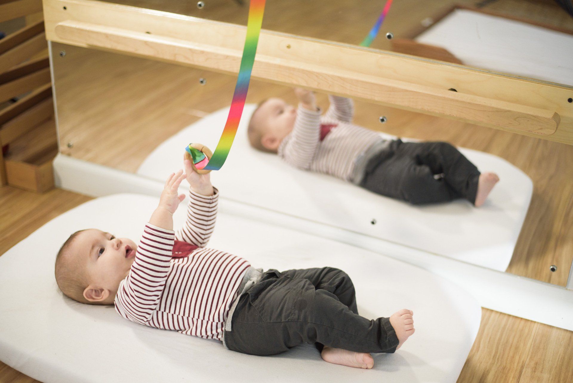 Infant laying on a mat in a Montessori classroom