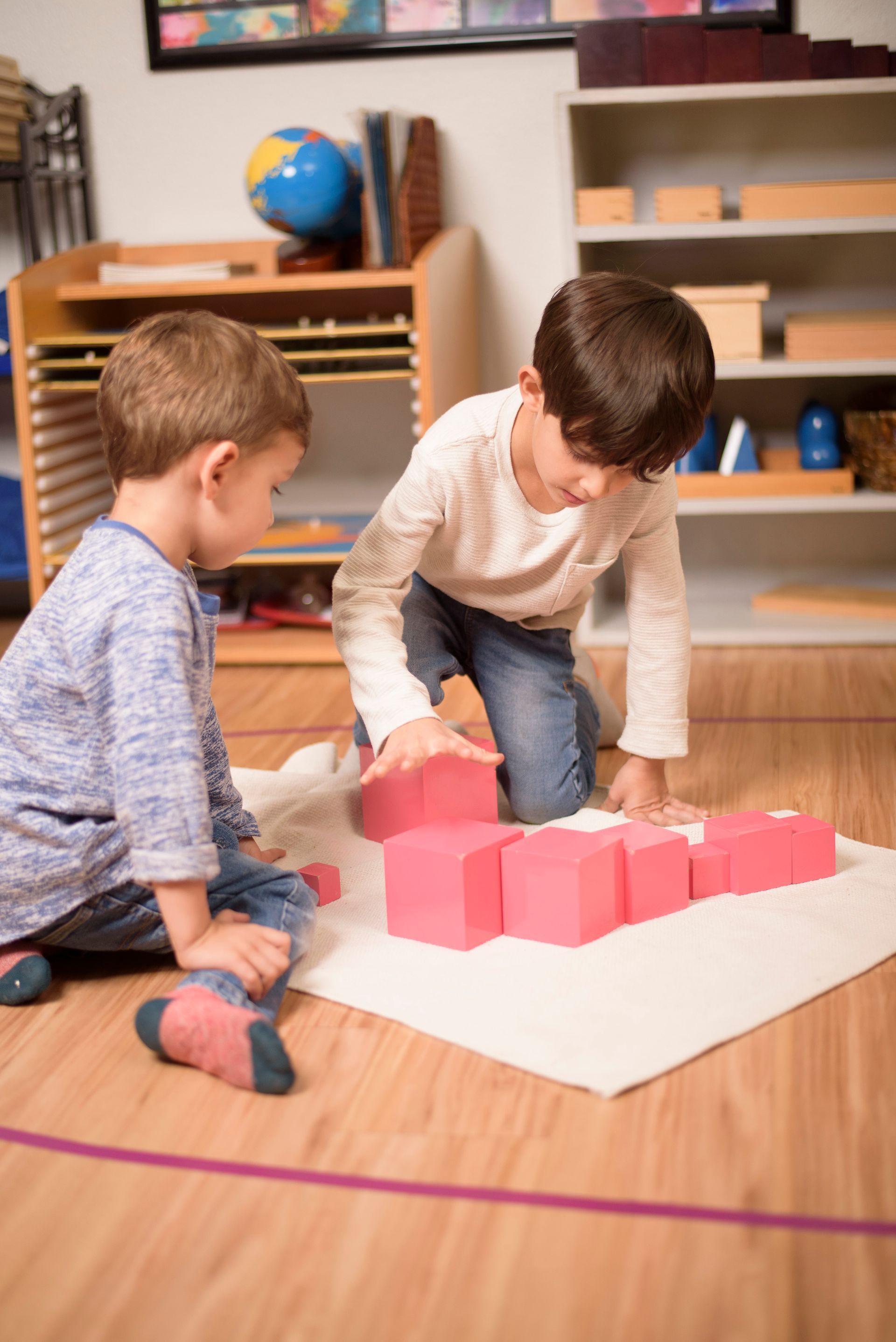 Children working together with the Montessori Pink Tower