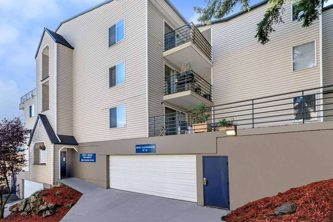 Apartment building exterior with garage, blue doors, and beige siding