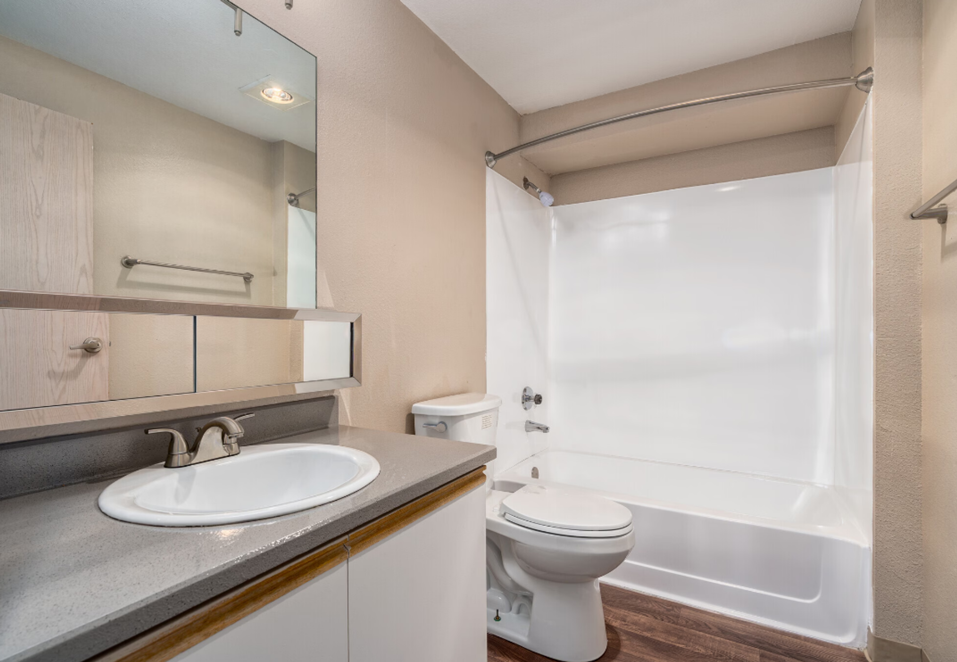 Bathroom with sink vanity, mirror, toilet, and white shower curtain.