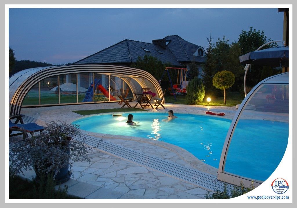 Swimmers in pool with retractable enclosure open