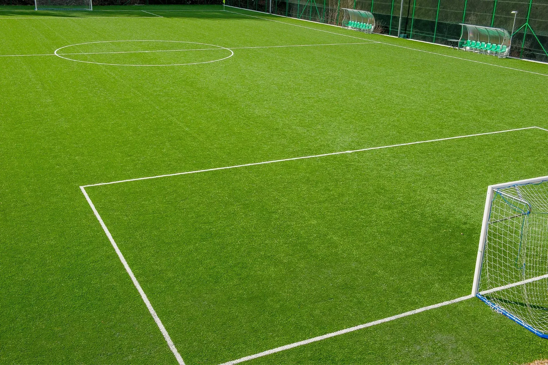 Henderson Artificial Turf-A well-maintained football field with vivid green grass, white boundary lines, and two visible goals. The field is empty, conveying a calm, pristine atmosphere.