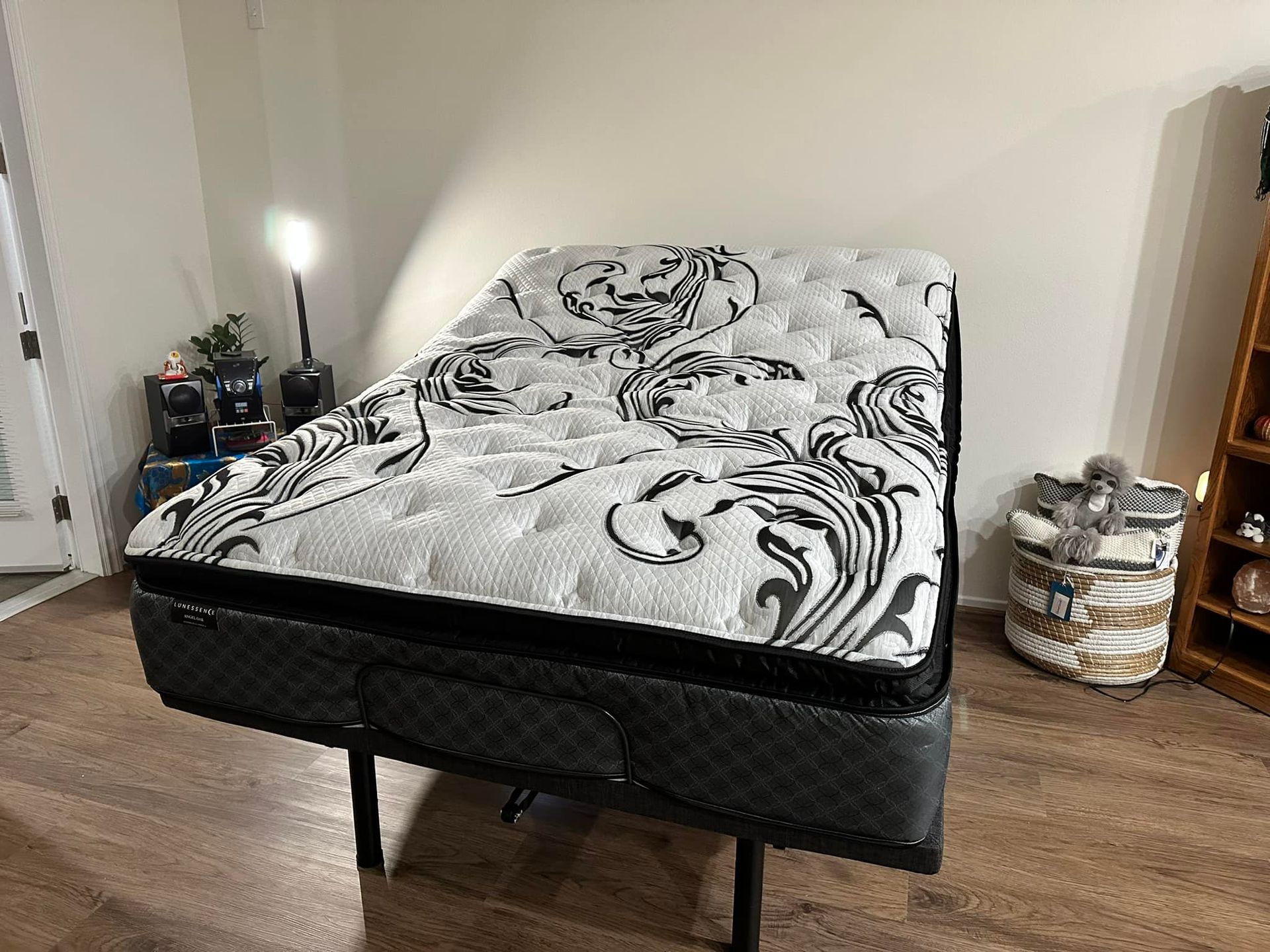 Adjustable bed with a white and black patterned mattress in a room.