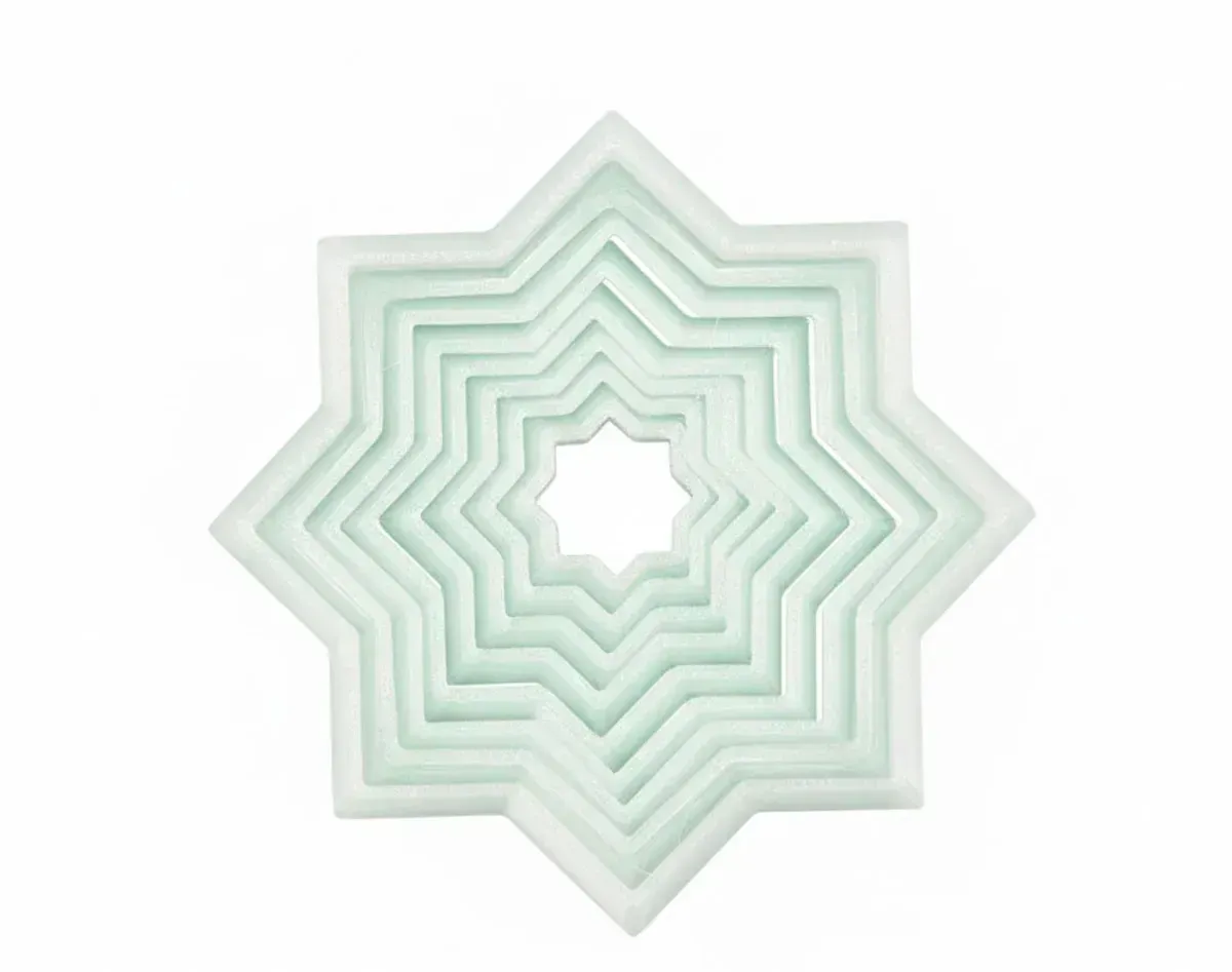 Mint-green layered starburst ornament with a white center on a light background