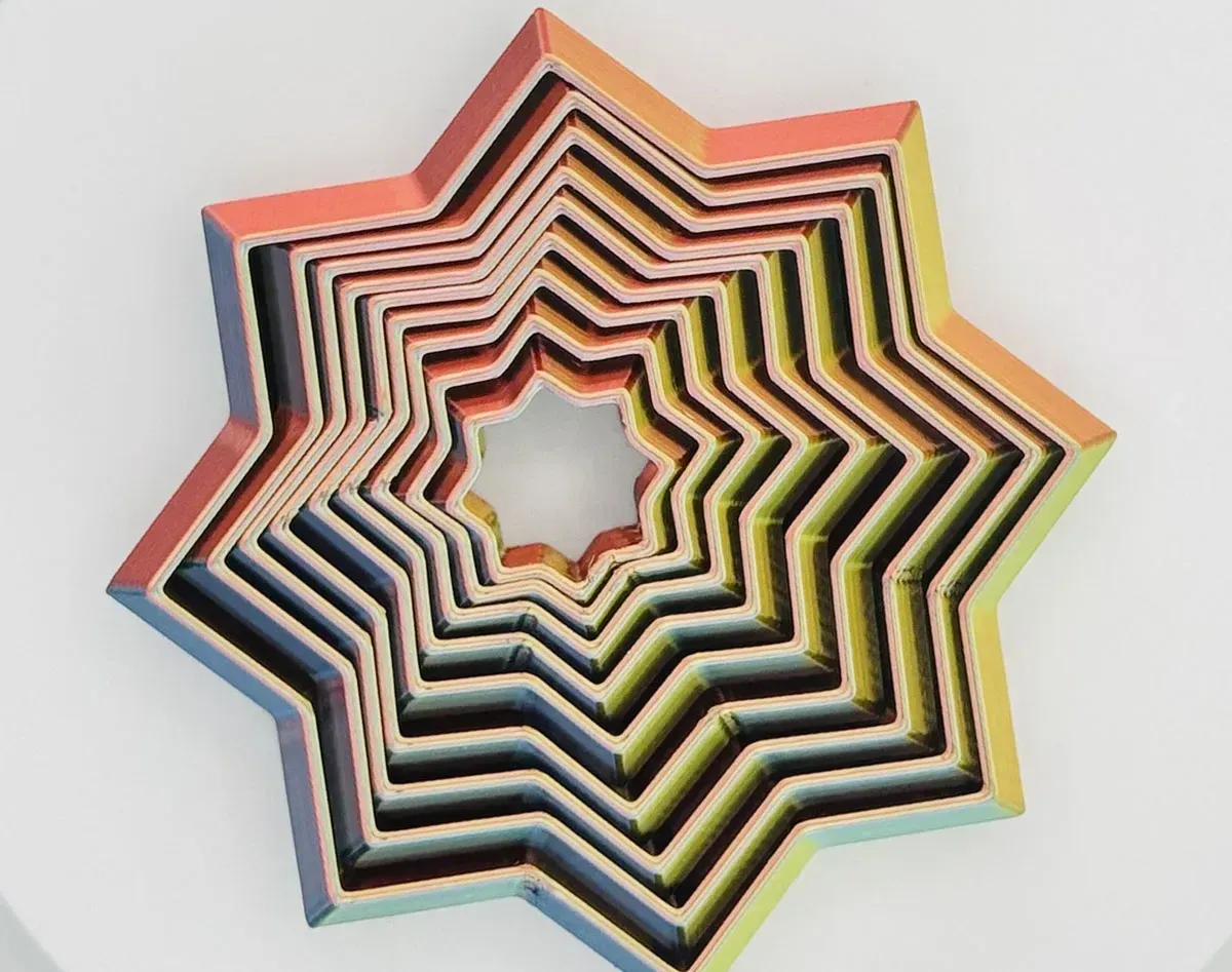 Multicolored layered star-shaped paper sculpture on a light background
