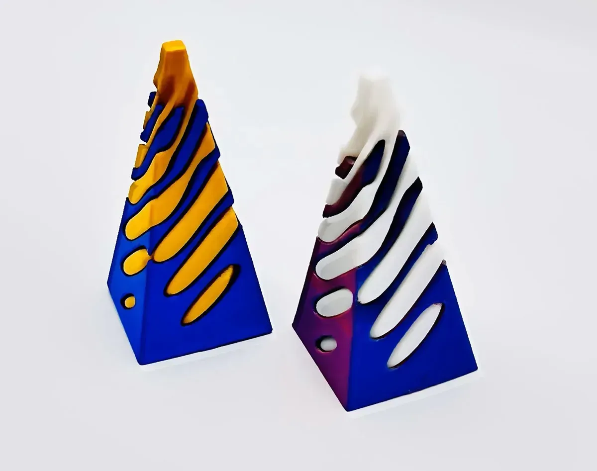 Two triangular blue and white abstract sculptures with orange and purple accents on a white background