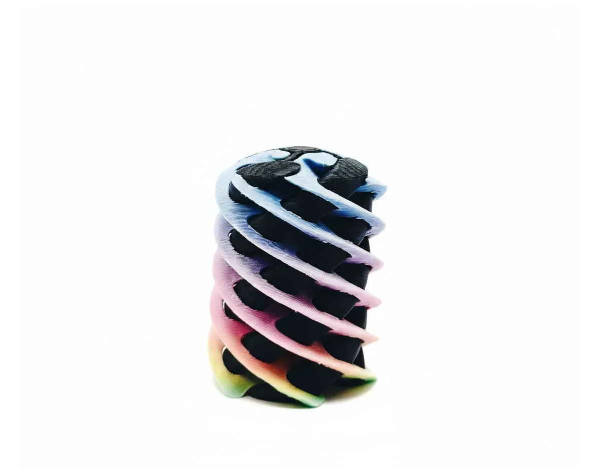 Colorful twisted spiral object with black, white, pink, and yellow bands on a white background