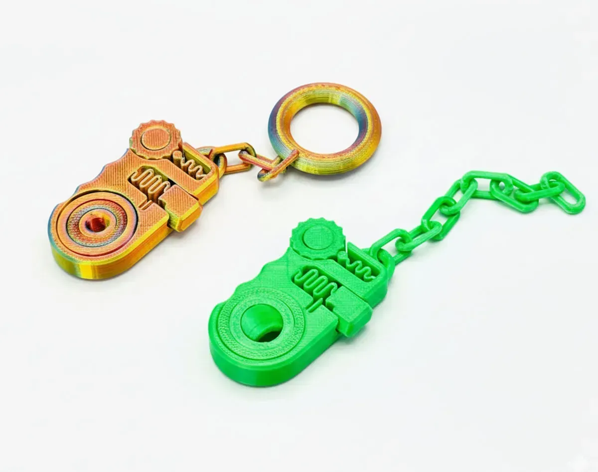 Two colorful toy keychains, one orange and one green, on a white background
