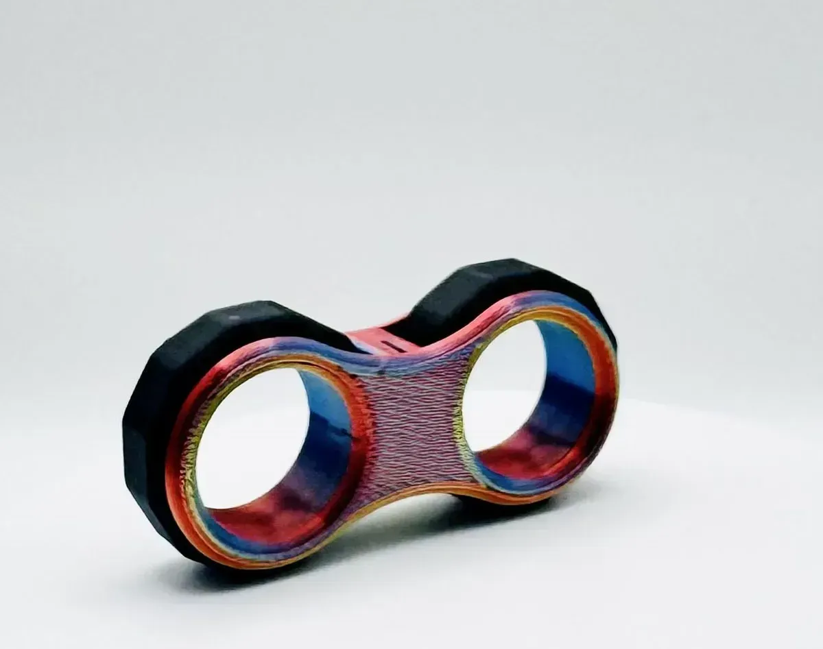 Colorful 3D-printed double ring fidget toy with two circular openings on a white background