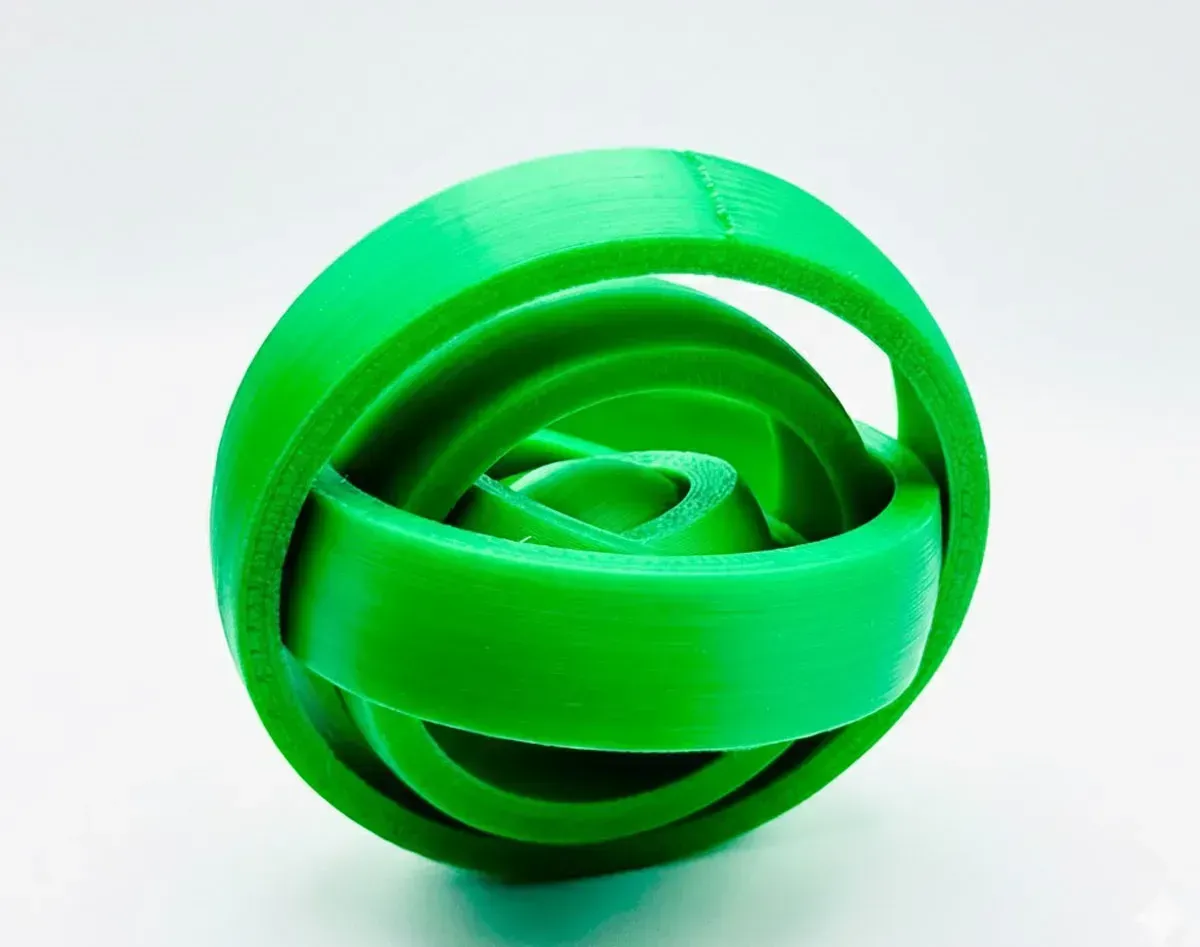 Green 3D-printed interlocking ring sculpture on a white background