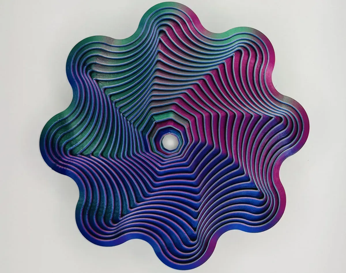 Colorful layered spiral flower with blue, purple, and pink gradients around a central hole