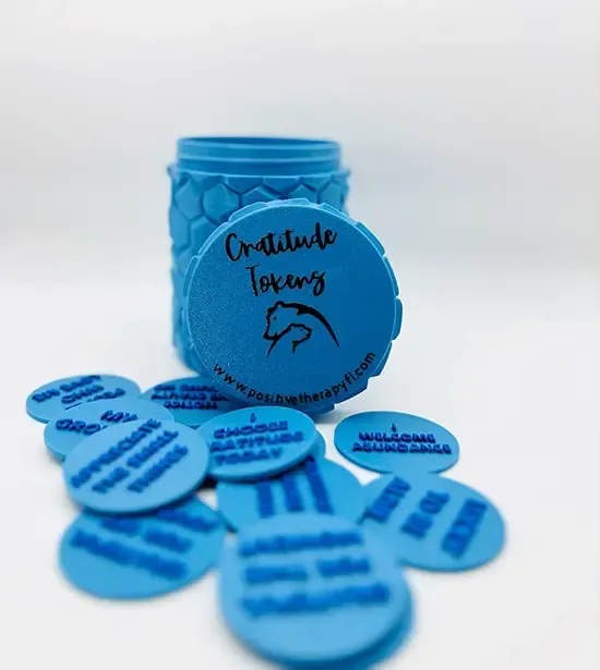 Blue jar with matching round tokens or tags scattered in front on a white background