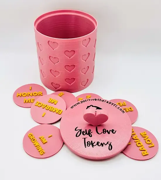 Pink self-love token jar with several heart-shaped pink tokens spread around it