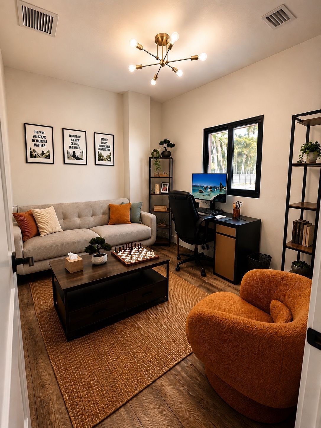 Cozy home office with sofa, desk by a window, coffee table, and orange accent chair.