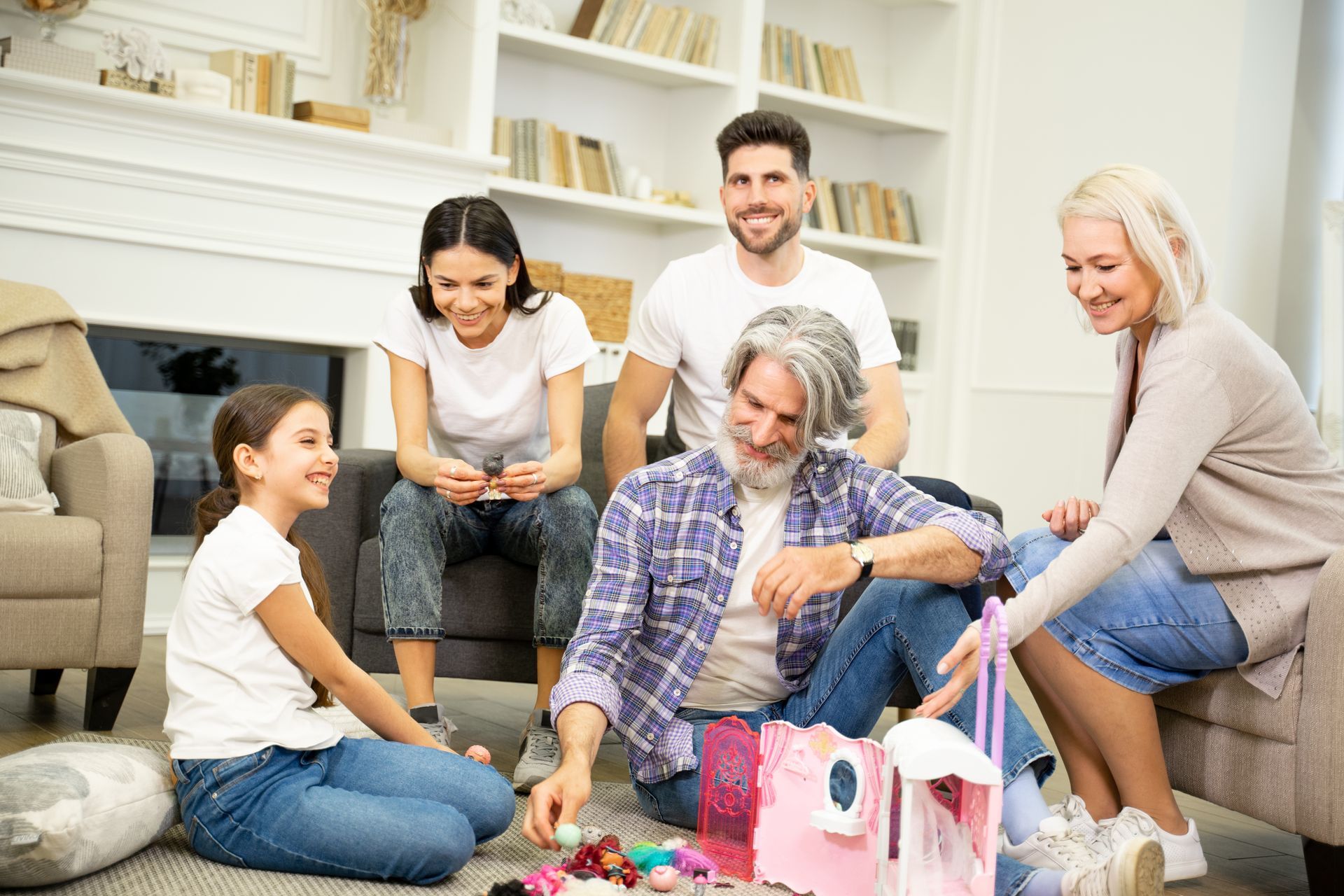 Friends gathered in a living room, smiling and opening gifts around a coffee table