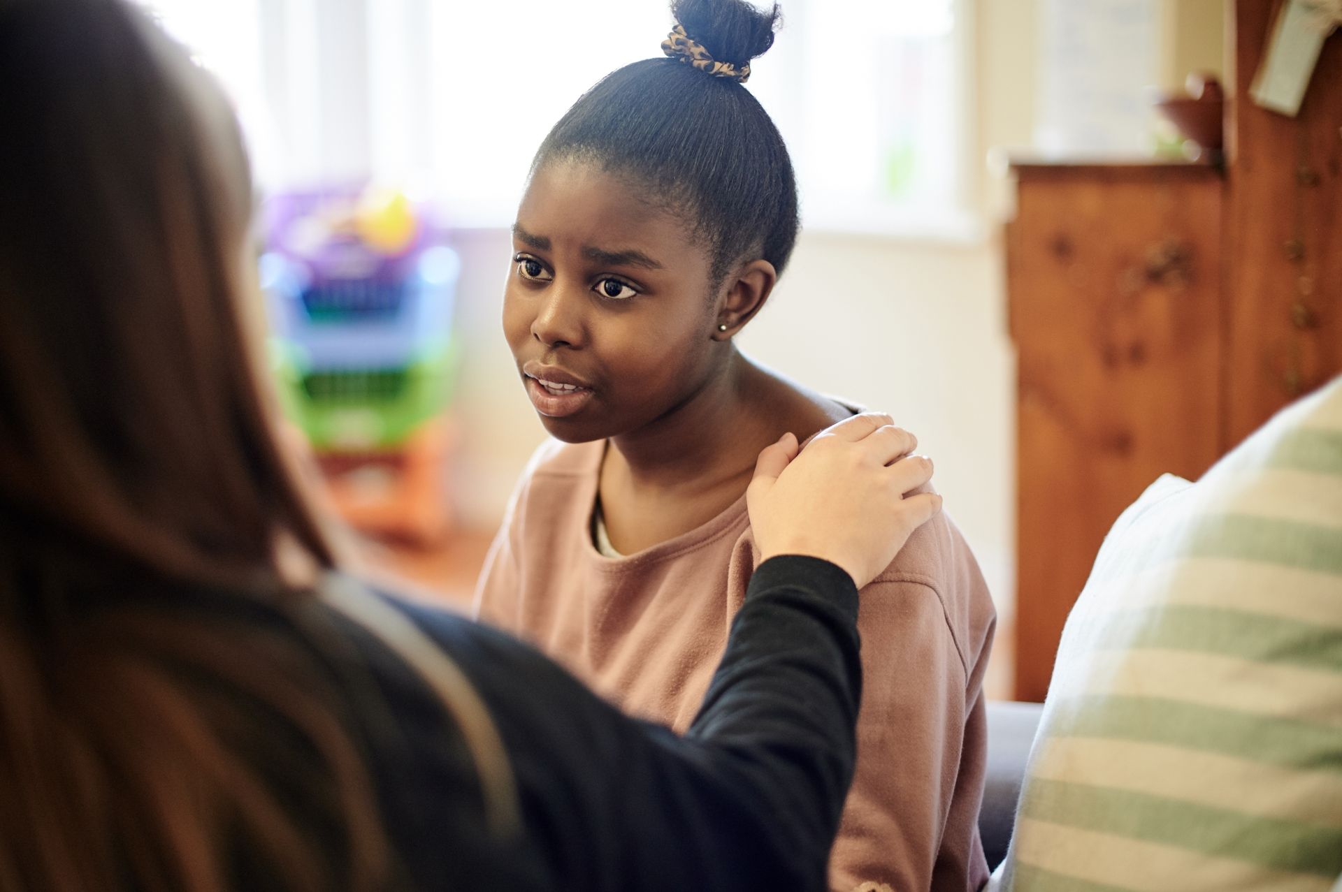 Woman comforting another person during a supportive conversation indoors