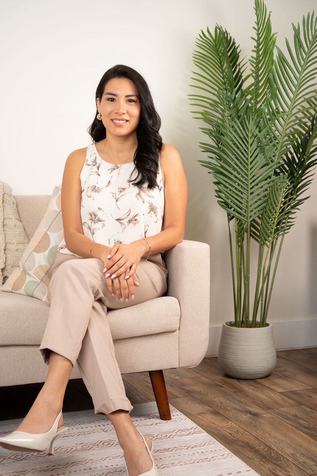 Smiling woman with long dark hair wearing a light green top against a plain white background