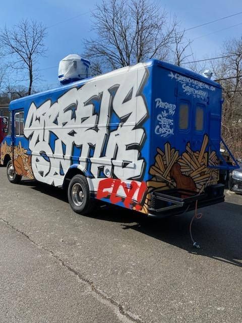 Blue and white food truck with graffiti 