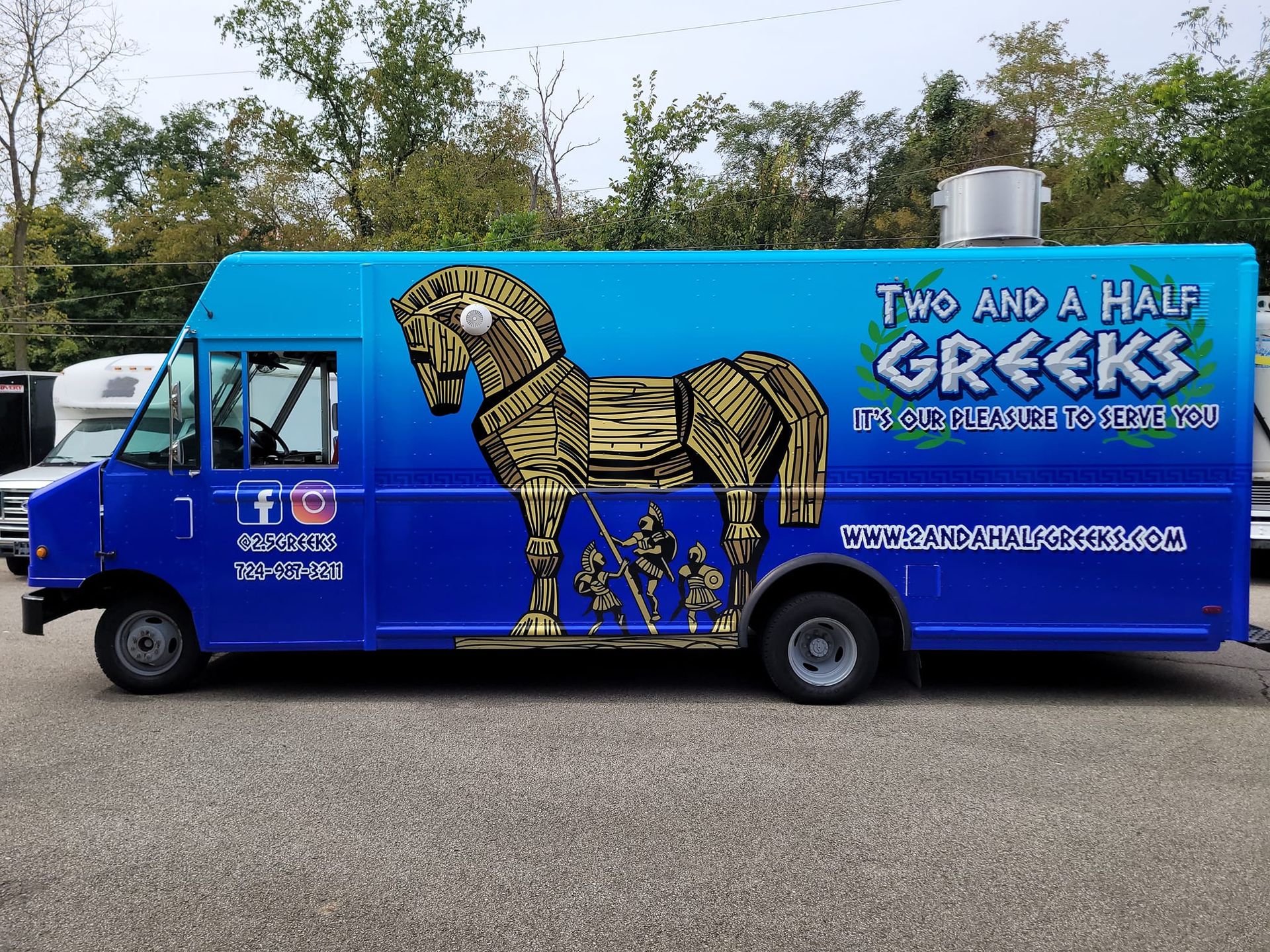 A blue food truck with a Trojan horse logo, 