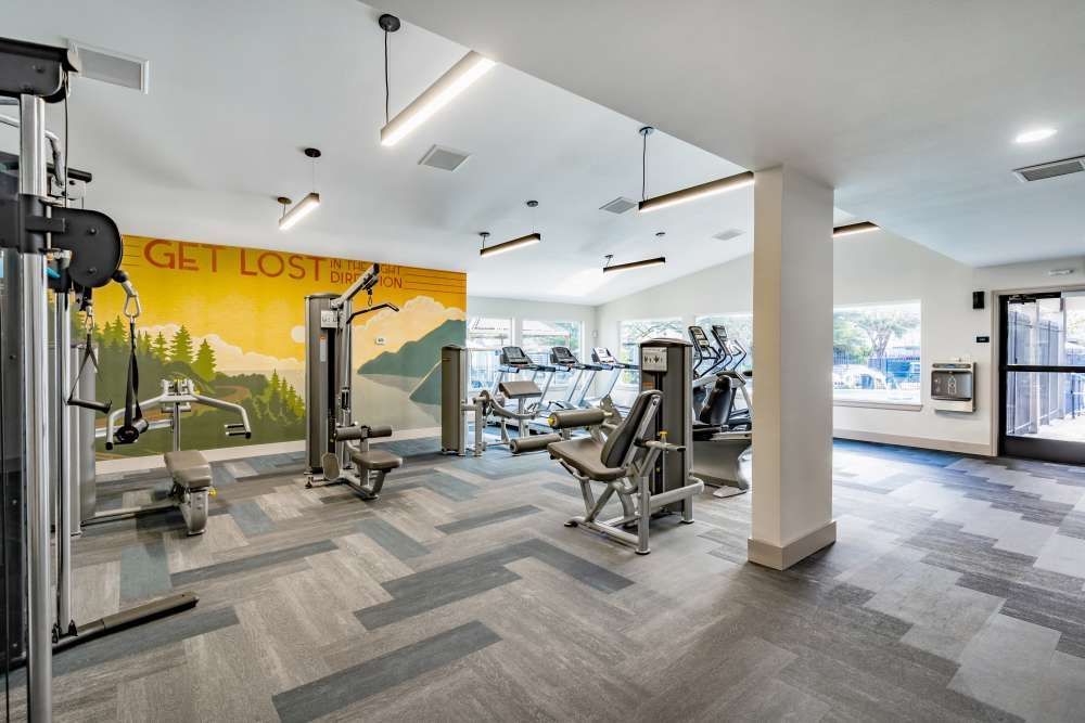 Gym interior with exercise machines, patterned carpet, and