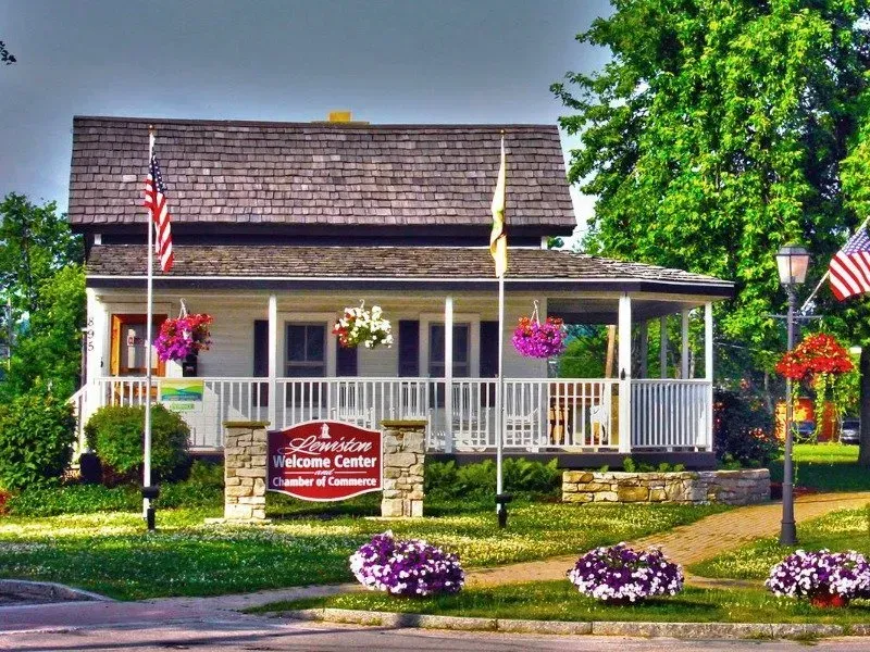 A white house with a welcome center sign in front of it