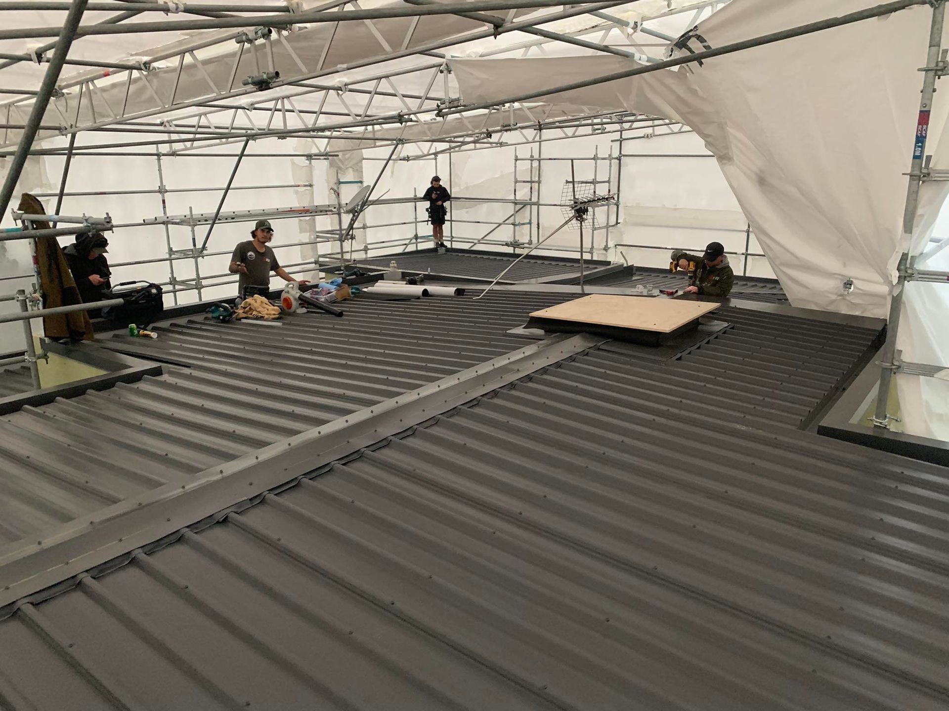 A group of people are working on the roof of a building.