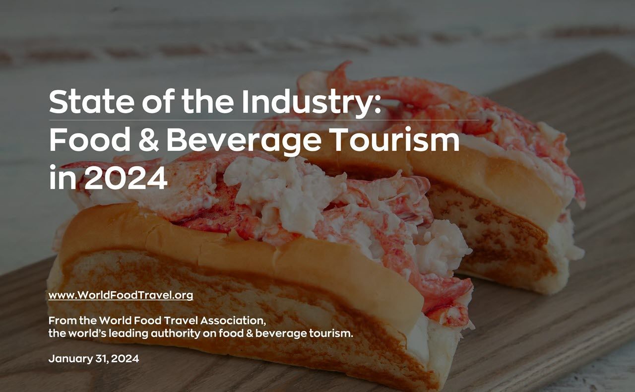 A lobster roll is cut in half on a wooden cutting board.