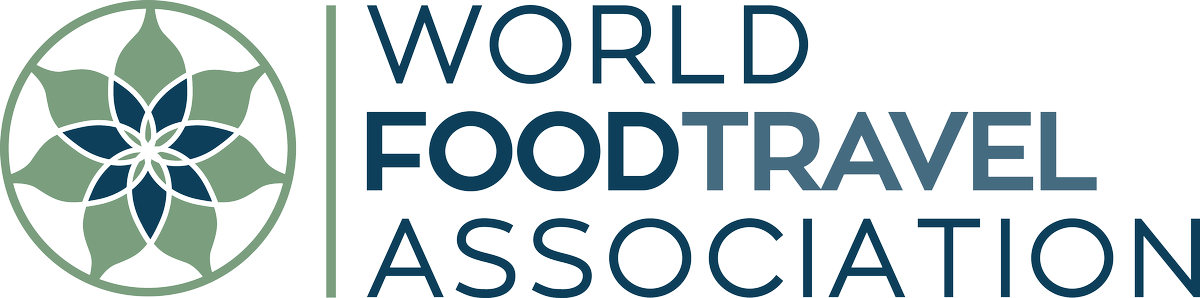 A logo for the world food travel association with a flower in the middle.