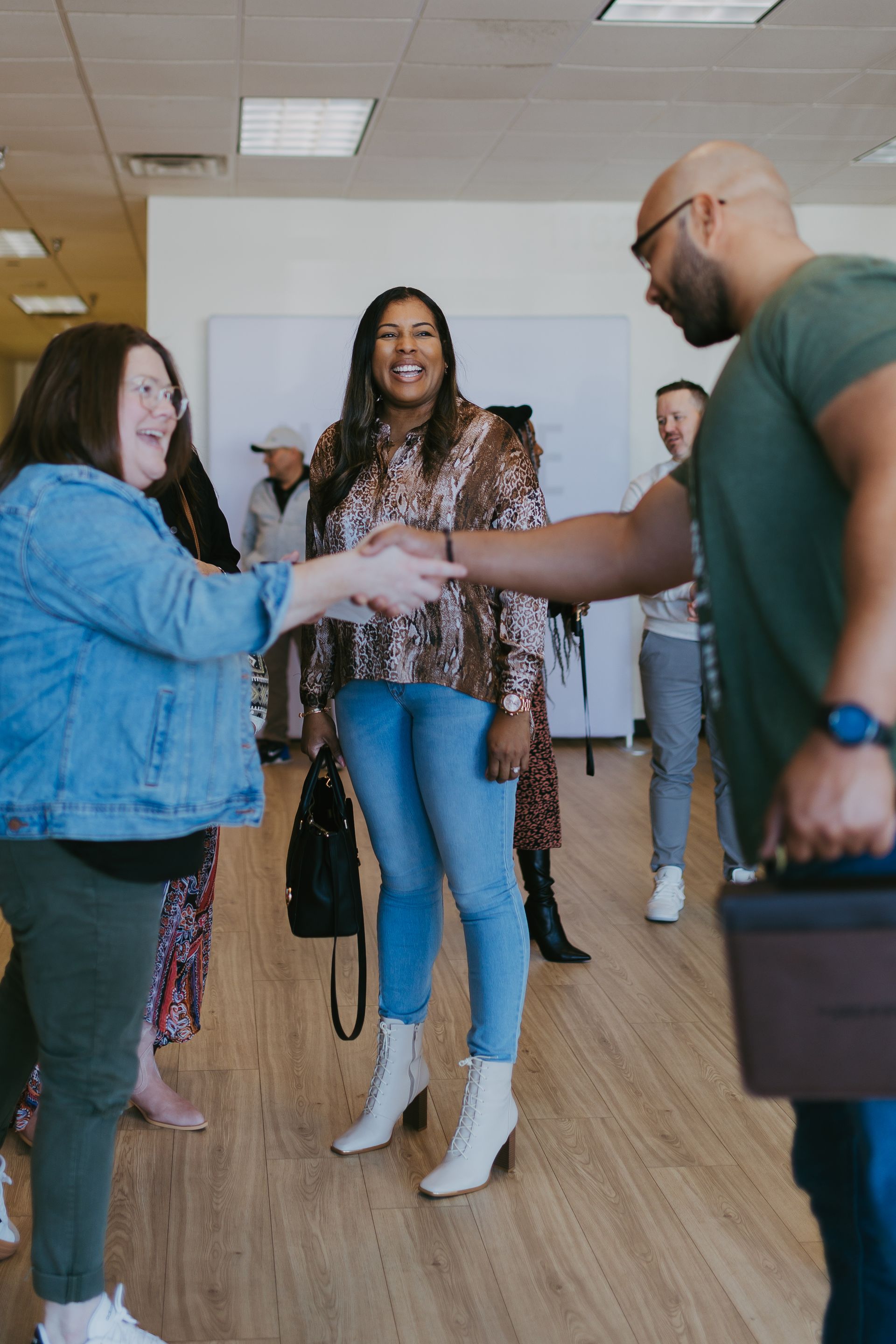 People greeting with handshakes in a bright office hallway