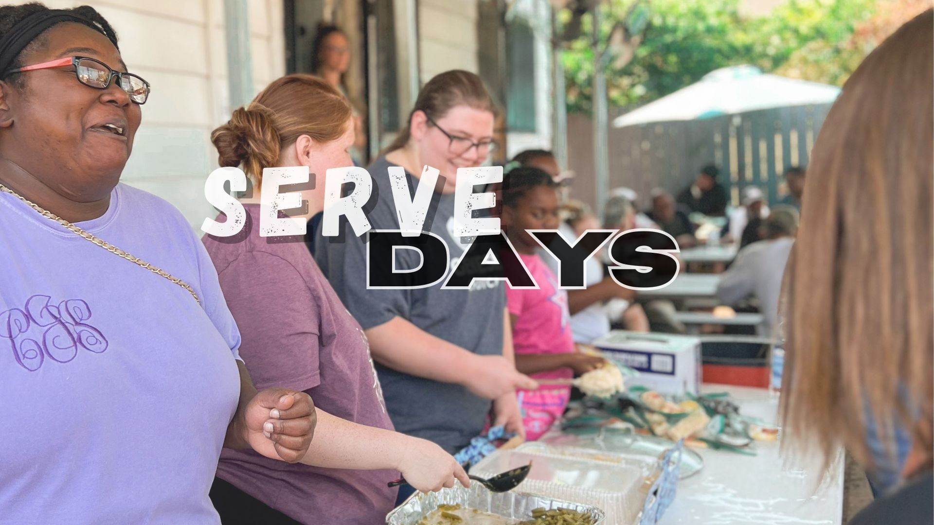 Volunteers serving food outdoors; 