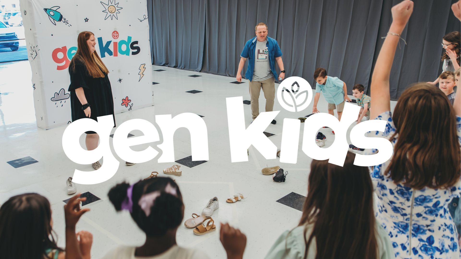 Children and adults in a room playing, with 
