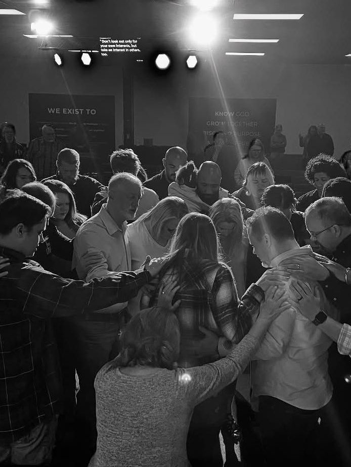 A black and white photo of a group of people standing in a circle.