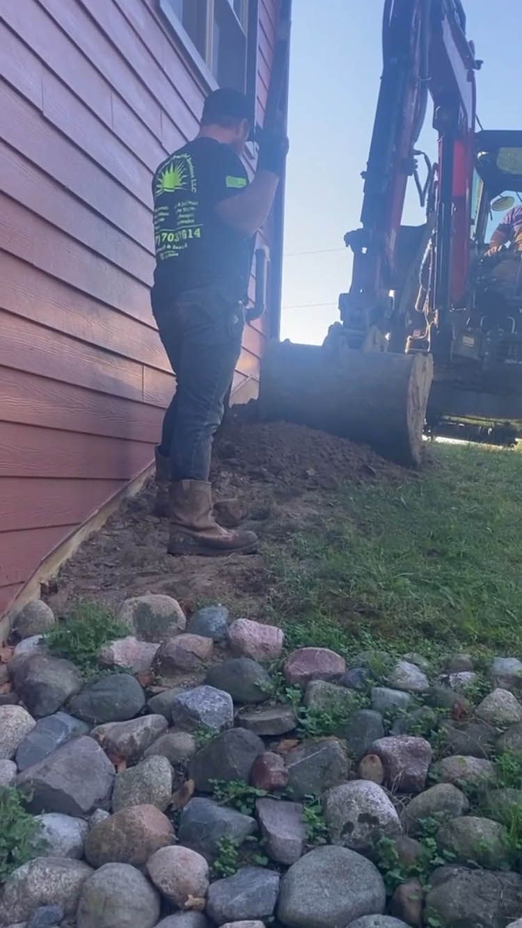 A man is digging a hole in the side of a house.