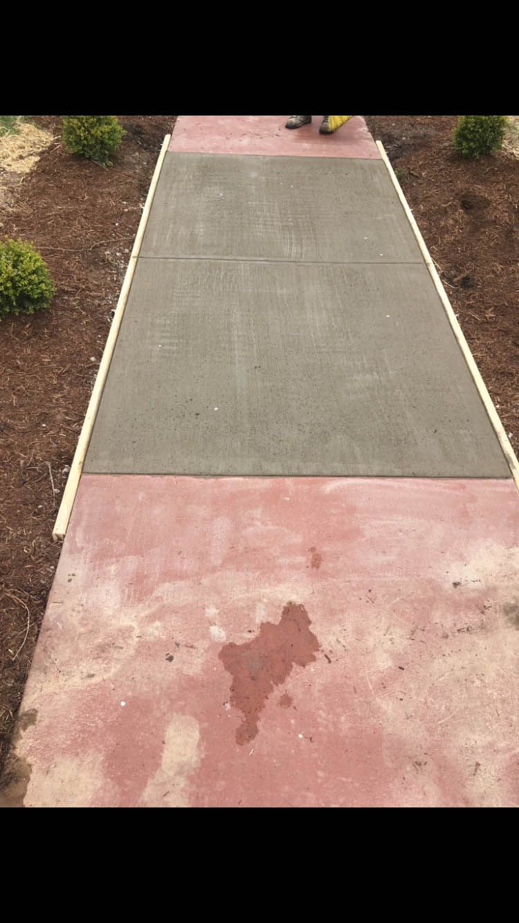 A concrete walkway with a shadow of a person on it.