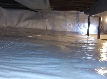 A basement with a lot of plastic on the floor and walls.